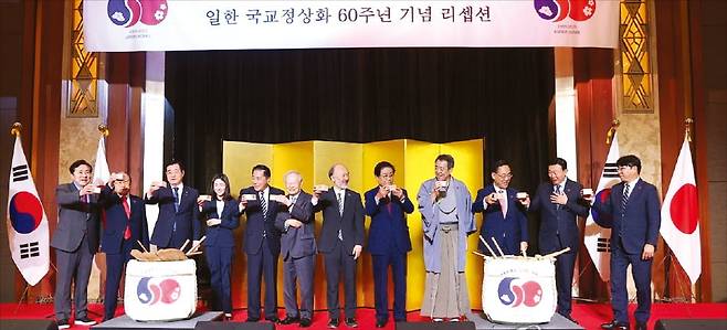 지난 16일 서울 중구 롯데호텔에서 열린 한일 국교정상화 60주년 기념행사에서 참석자들이 건배하며 기념 촬영하고 있다.  연합뉴스