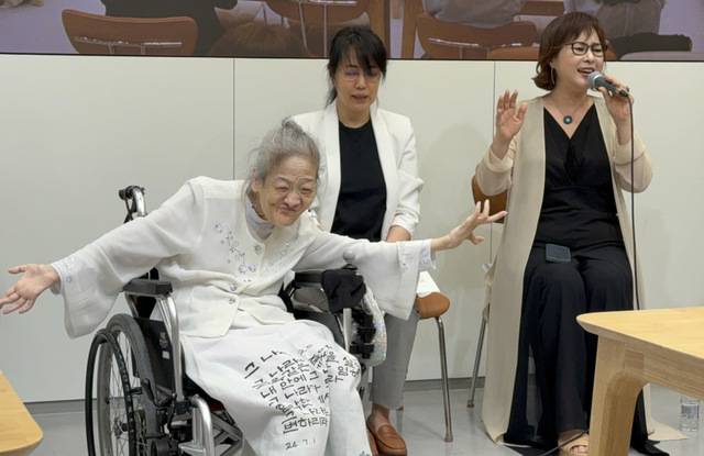 송명희(왼쪽) 시인이 21일 경기도 성남 만나교회에서 열린 ‘40주년 기념 시집 발표회’에서 찬양사역자 송정미(오른쪽) 교수의 찬양에 맞춰 휠체어에 앉은 채 춤을 추고 있다.