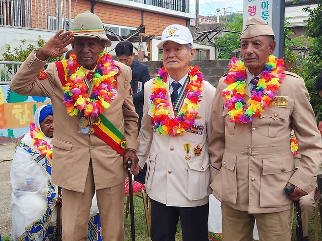 에티오피아 참전용사 뜰라운 테세마와 벨라체우 아메네쉐, 한국 6·25 참전용사 이춘술 포항지회장이 22일 포항 양포교회 앞 잔디마당에서 손을 맞잡고 기념촬영을 하고 있다.