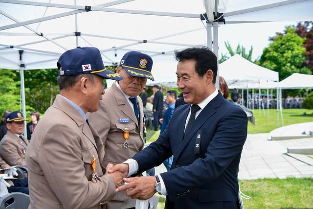 지난 6월 6일 열린 현충일 추념식 행사에서 백영현(오른쪽) 포천시장이 국가유공자들과 인사를 나누고 있다. 포천시 제공