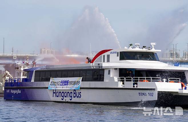 [서울=뉴시스] 김명년 기자 = 23일 오전 서울 영등포구 마포대교 인근에서 열린 한강버스 수난사고 대비 민관합동 현장 대응훈련에서 소방이 화재를 진압하고 있다.(공동취재) 2025.04.23. kmn@newsis.com