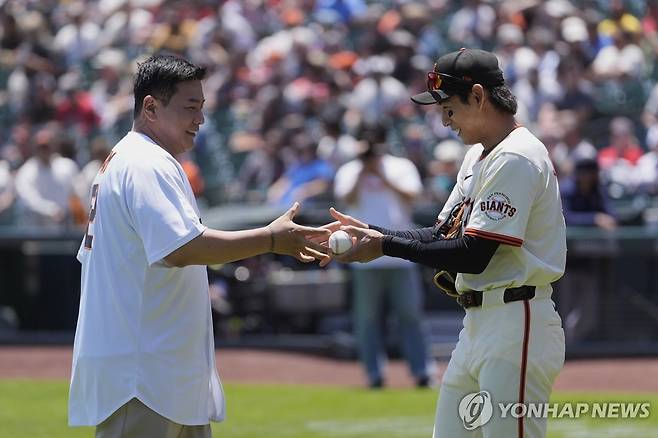 시구한 김태균 해설위원(왼쪽)과 공을 받은 이정후 [AP=연합뉴스]