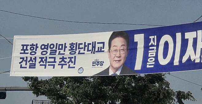 2025년도 제2차 추가경정예산안에서 정부가 24일 포항 영일만대교 건설 예산 1821억 원을 전액 삭감한 결정에 대해 국민의힘 김정재 의원(포항북)과 이상휘 의원(포항남·울릉)이 공동 성명서를 발표하며 정부의 의지 부족을 지적했다. 이들은 대선 공약으로 추진됐던 영일만 횡단대교 건설이 철회된 것에 대해 강한 유감을 표명하며, 정부가 국민의 약속을 지켜야 한다고 촉구했다. 21대 대선 선거운동 기간인 지난 달 포항시내에 이재명 대통령 후보의 ‘포항 영일만 횡단대교 건설 적극 추진’ 현수막이 걸려 있다. /독자 제공