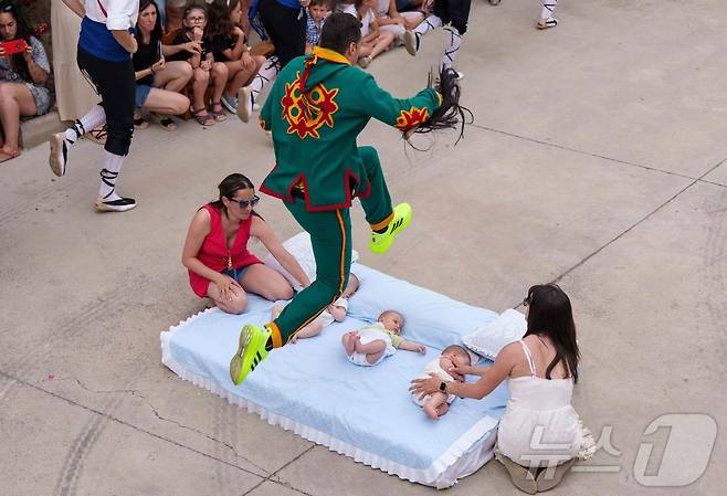 22일(현지시간) 스페인 부르고스 인근 카스트리요 드 무르시아 마을에서 열린 '엘 콜라초(El Colacho)'축제에서 악마를 상징하는 '콜라초'가 아기들을 뛰어넘고 있다.ⓒ AFP=뉴스1