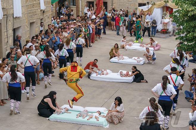 22일(현지시간) 스페인 부르고스 인근 카스트리요 드 무르시아 마을에서 열린 '엘 콜라초(El Colacho)'축제에서 악마를 상징하는 '콜라초'가 아기들을 뛰어넘고 있다.ⓒ AFP=뉴스1