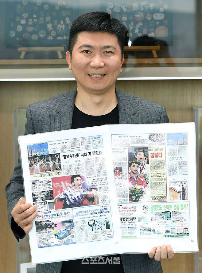 스포츠서울 창간 40주년 인터뷰에서 만난 유승민 대한체육회장이 21년 전인 2004년 아테네 올림픽 탁구 남자 단식 출전 당시 세계 최강자 왕하오(중국)를 꺾고 역사적인 금메달을 차지한 순간이 담긴 본지 지면을 바라보며 웃고 있다. 박진업 기자 upandup@sportsseoul.com
