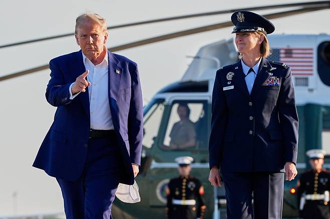 도널드 트럼프 미국 대통령이 24일 미국 메릴랜드주(州) 앤드루스 공군기지에서 공군 장교와 함께 대통령 전용기 에어포스원 탑승을 위해 이동하고 있다. 트럼프는 전날 자신의 소셜미디어를 통해 이스라엘과 이란이 휴전에 합의했다고 깜짝 발표했고, 이날 나토 정상회의 참석을 위해 네덜란드로 이동했다./AP 연합뉴스