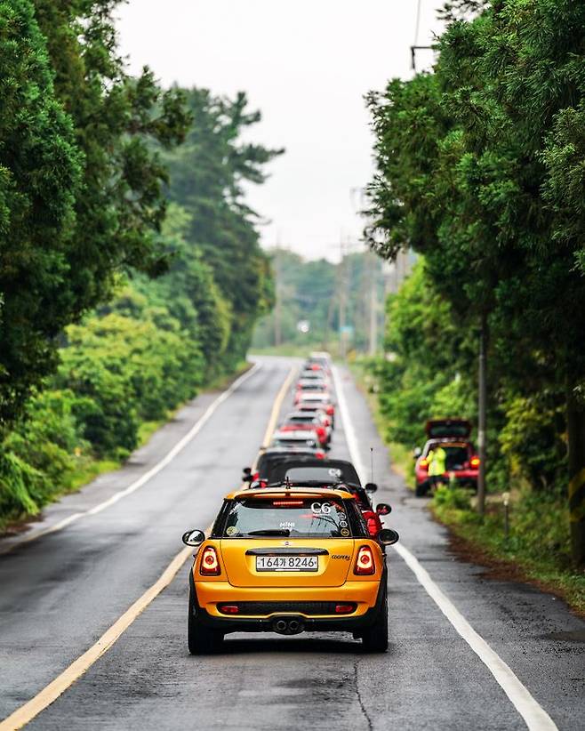 도로 우측에서 달리는 미니 행렬을 사진에 담고 있는 운영진. 주행 코스 곳곳을 달리다보면 언제 도착했는지 모를 운영진들을 만나게 된다.ⓒ데일리안 편은지 기자