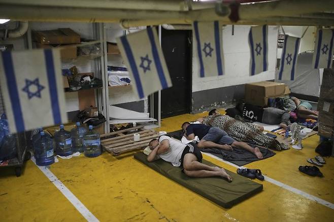 24일(현지시간) 이스라엘 텔아비브의 지하 주차장에서 이란의 미사일 공격을 피해 도망친 난민들이 잠을 청하고 있다.AP뉴시스