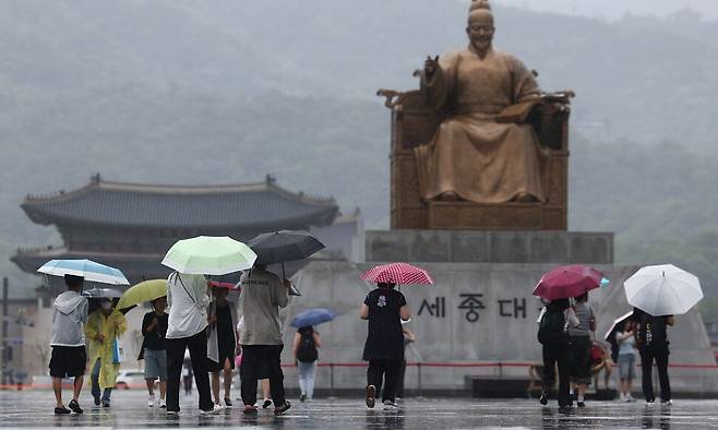 서울 전역에 호우주의보가 내린 20일 서울 종로구 광화문 광장에서 우산을 쓴 시민들이 이동하고 있다. 연합뉴스