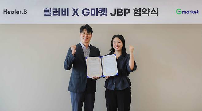 조성훈(왼쪽) 힐러비 브랜드커머스 그룹장과 유보연 지마켓 뷰티 팀장이 서울 강남구 지마켓 본사에서 열린 업무 협약식에서 기념 촬영을 하고 있다. 코웨이 제공