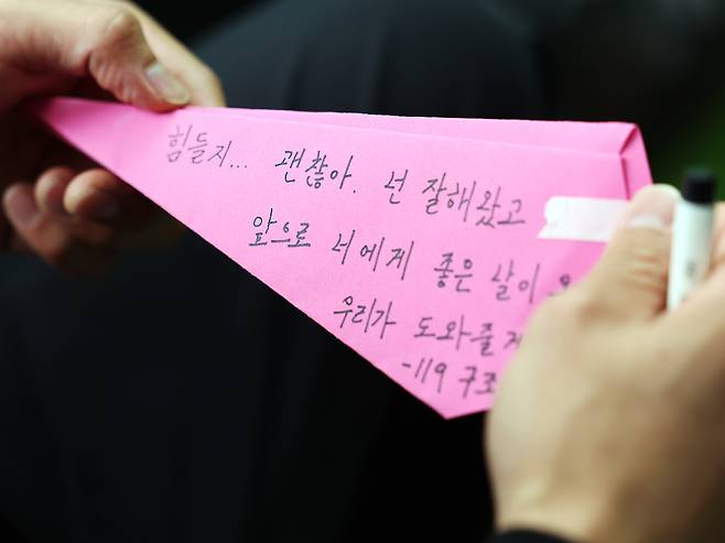 지난해 10월 열린 생명존중 캠페인 행사에서 119 구조대원이 종이 비행기에 응원 메시지를 적고 있다. 뉴스1