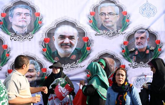14일(현지시간) 이란 테헤란에서 전날 이스라엘 공습으로 사망한 군 수뇌부와 핵 과학자들의 사진이 걸린 광고판 앞을 지나치고 있다. EPA=연합뉴스