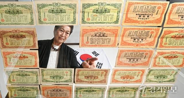 장성숙 ㈔중소기업융합경기연합회 고문이 부친이 생전 구입한 건국국채 증서를 펼쳐 보이고 있다. 광복 직후 재정난을 타개하고 6·25전쟁 당시 군수 물자를 조달하기 위해 발행된 건국국채는 대한민국 경제의 초석이 되었으나 대부분이 상환되지 못한 채 역사 속에 잊혀졌다. 조주현기자
