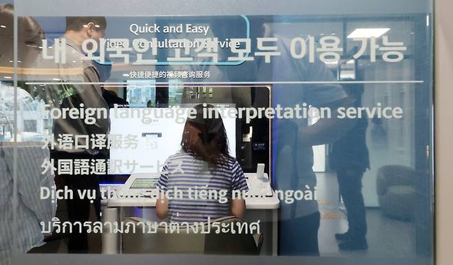 신한은행 독산동 외국인 중심 영업점에서 한 시민이 업루를 보고 있다. [이승환 기자]