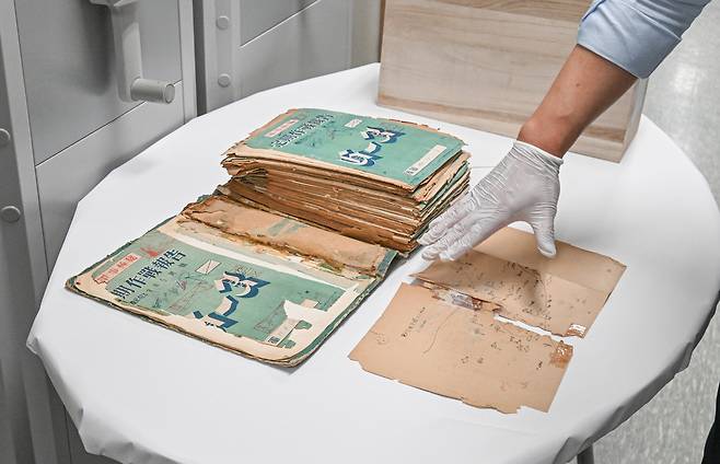 육군은 6.25전쟁 75주년을 맞아, 23일 충남 계룡대 육군기록정보관리단에서 ‘중요 역사기록물 복원사업’ 현장을 공개했다. 육군기록정보관리단 관계관이 복원 작업 전 기록물의 손상 상태에 대해 설명하고 있다. [육군 제공]