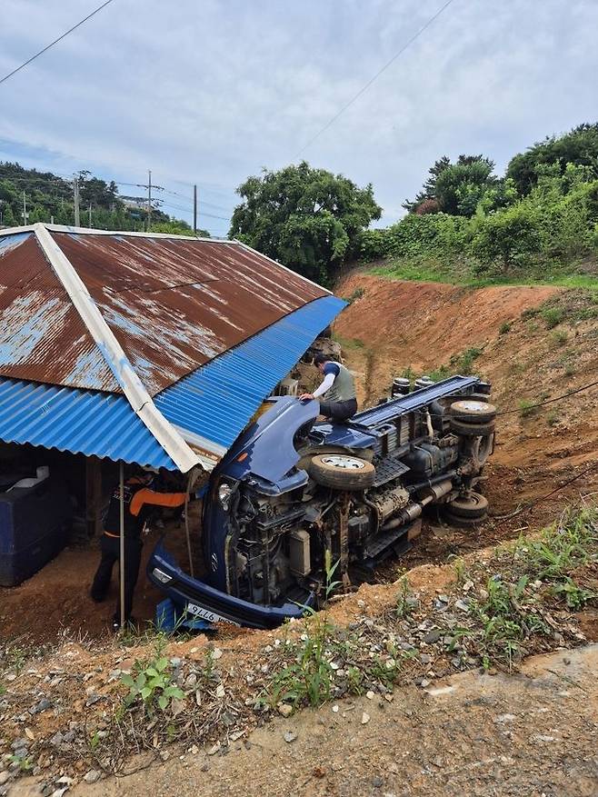 [태안=뉴시스] 24일 오전 10시21분께 충남 태안군 남면 신온리의 한 단독주택 뒷길에서 후진하던 1t 트럭이 5m 아래로 굴러 떨어진 후 전도돼 현장에 출동한 소방대원이 운전자 구조에 나서고 있다. (사진=태안소방서 제공) 2025.06.24. photo@newsis.com  *재판매 및 DB 금지