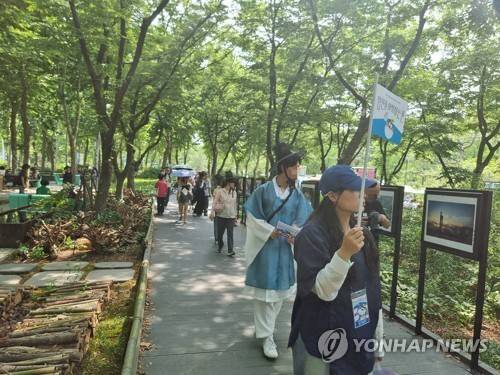 정원을 거닐며 (서울=연합뉴스) 서윤호 인턴기자 = 지난 19일 오후 서울 동작구 보라매공원에서 '정원을 여행하는 돌: 서울정원 여행자' 프로그램 참가자들이 공원 사진을 둘러보고 있다. 2025.6.24