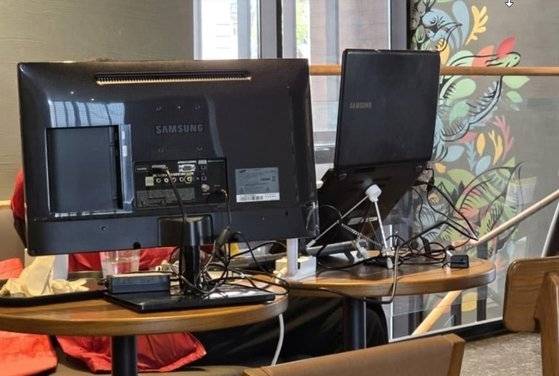 지난해 한 스타벅스 매장에서 한 이용객이 컴퓨터 모니터와 노트북 등을 충전하고 사용하는 모습 〈출처 : 온라인 커뮤니티〉