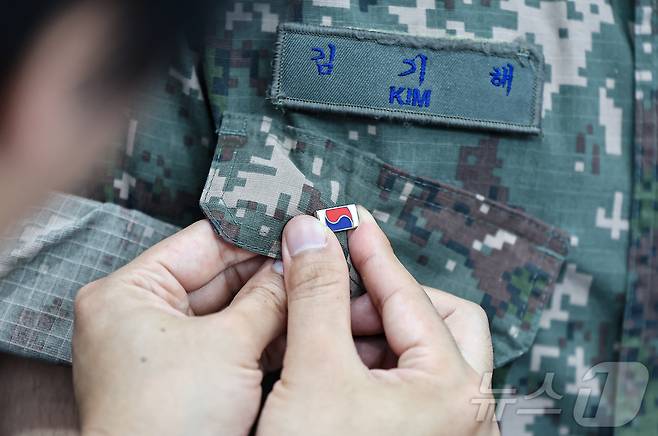 25일 서울 중구 서울역 대합실에 마련된 '태극기 부스'에서 군인들이 태극기 배지를 패용하고 있다.  2025.6.25/뉴스1 ⓒ News1 김도우 기자