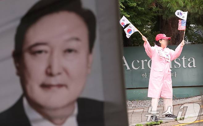 25일 서울 서초구 아크로비스타 윤석열 전 대통령 사저 앞에서 한 지지자가 태극기를 흔들고 있다.  2025.6.25/뉴스1 ⓒ News1 김성진 기자