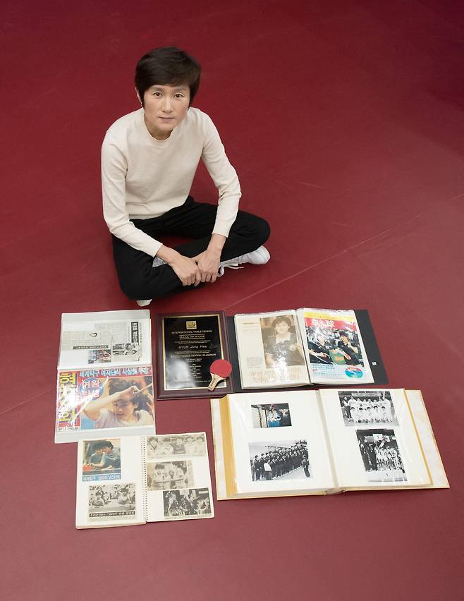 현정화 감독이 인천 청라동 한국마사회 탁구단 연습장에서 옛 앨범과 스크랩북을 펼쳐 보이고 있다. 분단 이후 첫 남북 단일팀으로 출전했던 1991년 일본 지바 세계선수권 대회 당시의 사진들과 경기 결과를 보도한 기사들이 갈무리돼 있다. /고운호 기자