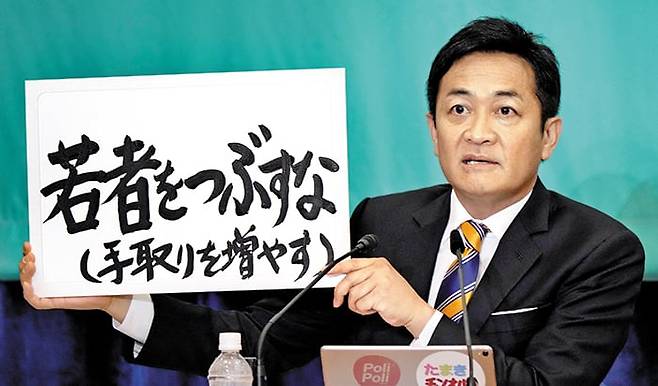 지난해 10월 일본 중의원 총선 토론회에서 다마키 유이치로 국민민주당 대표가 ‘젊은이를 망치지 마라’라고 적힌 피켓을 들어 보이고 있다./로이터 뉴스1