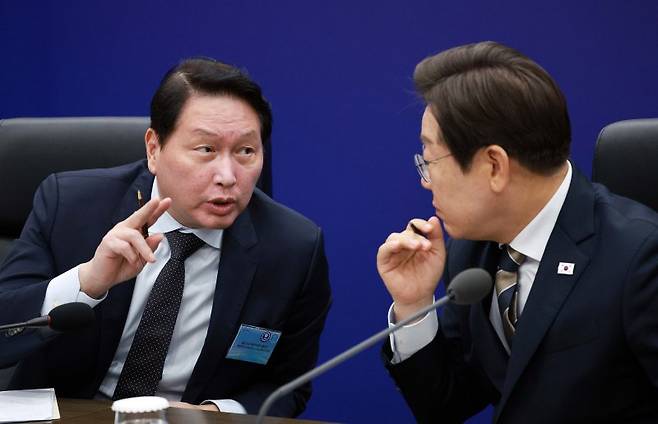 이재명 대통령이 지난 20일 울산전시컨벤션센터에서 열린 AI글로벌 협력 기업 간담회에서 최태원 SK그룹 회장과 대화하고 있다. 뉴시스