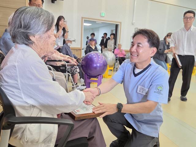 ▲ 24일 원주보훈요양원 일일요양보호사로 나선 김 지사가 유공자 어르신에게 감사패를 전달한 후 건강을 묻고 있다.  권혜민 기자