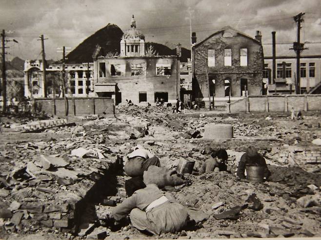 Civilians comb through rubble in downtown Seoul, Nov. 1, 1950. The badly damaged General Government Building, a relic of the Japanese occupation of Korea, is visible in the distance. [U.S. NATIONAL ARCHIVES]