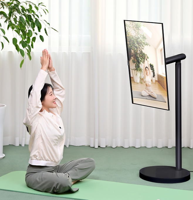 삼성전자 모델이 2025년형 삼성 스마트모니터 M7에 무빙스탠드 신제품을 결합한 ‘무빙스타일 M7’으로 홈트레이닝 영상을 시청하고 있다. [사진출처 = 삼성전자]