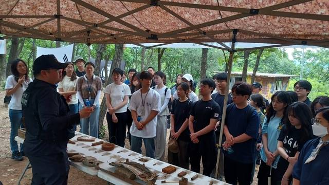 국방부 유해발굴단 오승래 발굴7팀장이 24일 경기도 파주시 광탄면에 위치한 박달산(370고지)의 6·25 미수습 전사자 유해발굴 현장을 찾은 국방부 직원들에게 해당 지역의 지형 및 전사, 발굴유품 등을 설명하고 있다. 국방부 제공