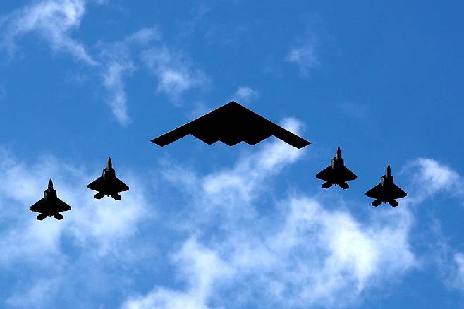 비행하는 B-2 폭격기를 현존 세계 최강 전투기로 알려진 F-22 전투기가 호위하고 있다. [로이터]