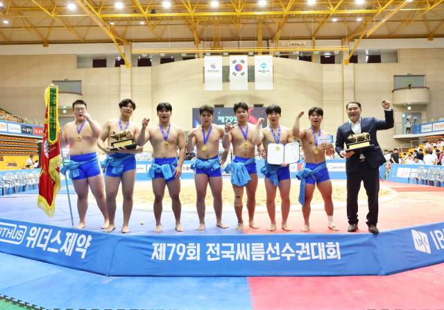 지난 25일 충북 제천체육관에서 열린 ‘제79회 전국씨름선수권대회’ 고등부 단체전 우승을 차지한 마산용마고등학교 선수들이 정진환 감독(오른쪽 첫 번째)과 함께 기념사진을 찍고 있다./마산용마고등학교/