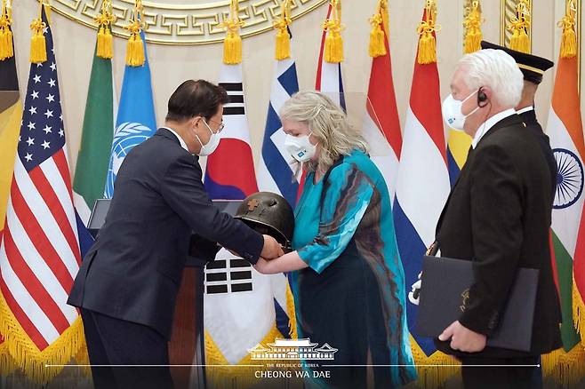 2021년 7월 에밀 카폰 신부의 조카 레이 카폰 부부가 청와대에서 문재인 대통령으로부터 철모를 형상화한 기념물과 태극무공훈장을 받고 있다./청와대 아카이브