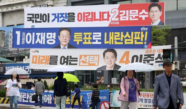 제21대 대통령 선거를 하루 앞뒀던 지난 2일 서울 영등포구 한 교차로에서 시민들이 대선 후보 현수막 앞을 지나고 있다. 뉴시스