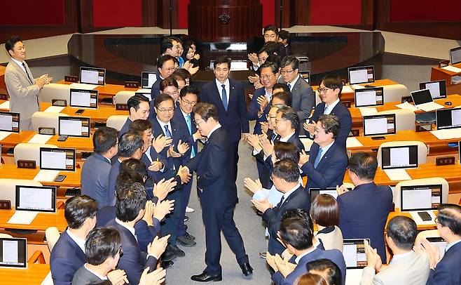 이재명 대통령이 26일 국회에서 추가경정예산 시정연설을 위해 본회의장에 입장하며 더불어민주당 의원들과 악수를 나누고 있다. 이상섭 기자