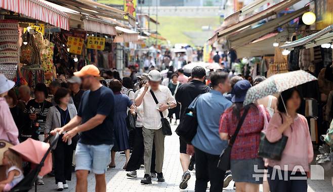 [서울=뉴시스] 김선웅 기자 = 지난 19일 서울 시내 상점가에서 시민들이 오가고 있다. 2025.06.19. mangusta@newsis.com