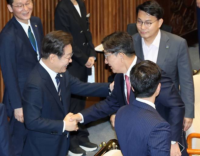 李, “김민석은 안 된다”는 권성동 어깨 ‘툭’ 이재명 대통령이 26일 서울 여의도 국회 본회의장에서 정부의 2차 추가경정예산안 제출과 관련해 첫 시정연설을 마치고 퇴장하며 중앙대 동문인 국민의힘 권성동 의원과 악수하고 있다.이재문 기자