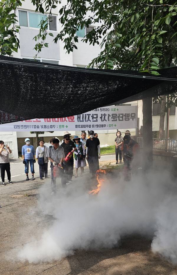 구미 송정우방타운1차 아파트 입주자대표회의와 송정119안전센터가 27일 주민 참여형 소화기 사용 시연회를 개최했다. 송정119안전센터가 소화기를 이용해 화재를 집압하는 시연을 펼쳐보이고 있다.