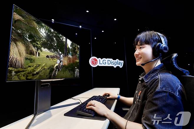 LG디스플레이 모델이 4세대 기술이 적용된 27인치 OLED 모니터 패널로 게임을 즐기고 있다.(LG디스플레이 제공)