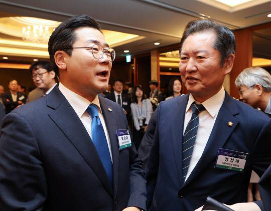 더불어민주당 당 대표에 출마한 정청래 의원과 박찬대 의원이 25일 서울 중구 롯데호텔에서 열린 '2025 경향포럼'에서 내빈들과 인사하고 있다. 연합뉴스