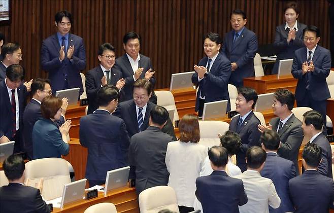 이재명 대통령이 26일 국회 본회의장에서 추가경정예산안에 대한 시정연설을 위해 입장하며 민주당 의원들과 인사하고 있다. ⓒ국회사진기자단