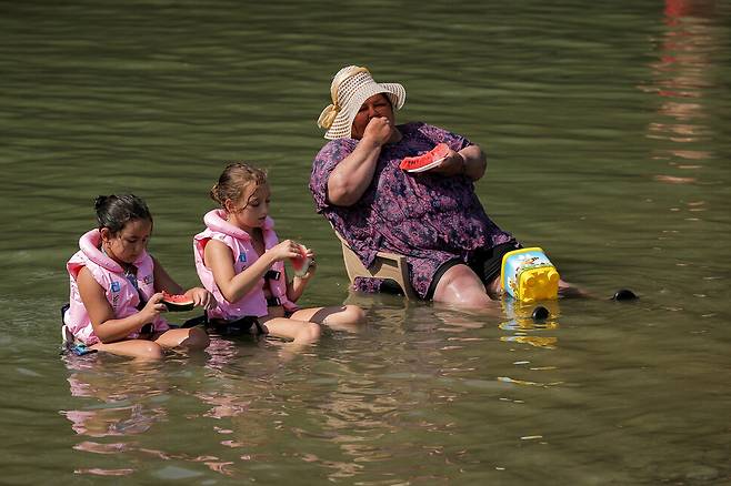 지난 25일(현지시각) 코소보 야코바 인근 에레니크강에서 사람들이 폭염 속에 수박을 먹으며 더위를 식히고 있다. 야코바/로이터 연합뉴스