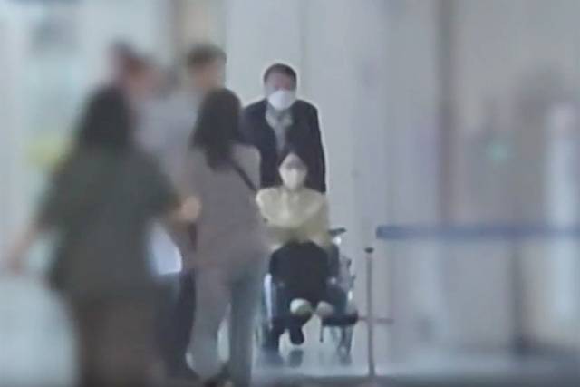 서울아산병원에 입원했던 김건희 여사가 27일 퇴원했다. 윤 전 대통령이 이날 오후 퇴원에 앞서 병원에서 김 여사의 휠체어를 밀어주고 있다. YTN 캡처