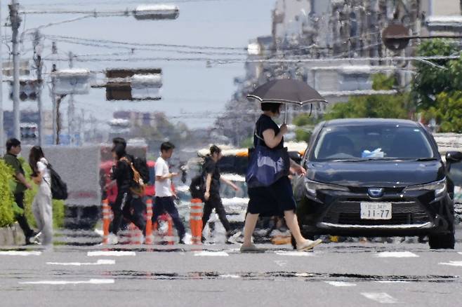 20일 일본 도쿄에서 뜨거운 햇볕이 내리쬐는 가운데 사람들이 길을 건너고 있다./AFPBBNews=뉴스1