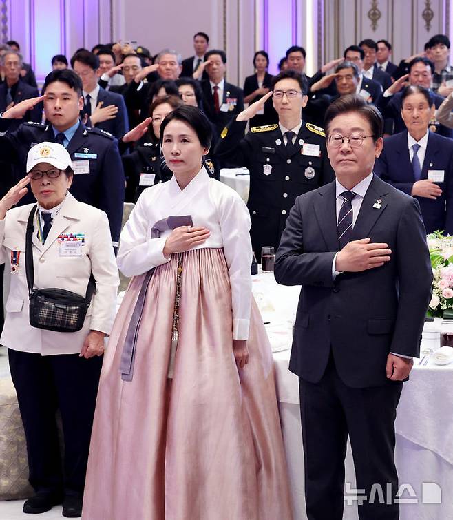 [서울=뉴시스] 최진석 기자 = 이재명 대통령과 부인 김혜경 여사가 27일 청와대 영빈관에서 열린 '호국보훈의 달, 대통령의 초대' 행사에서 국기에 경례하고 있다. (대통령실통신사진기자단) 2025.06.27. myjs@newsis.com