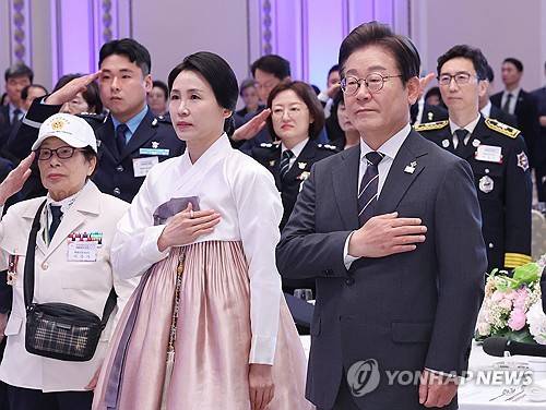이재명 대통령과 김혜경 여사가 27일 청와대 영빈관에서 열린 '호국 보훈의 달, 대통령의 초대' 행사에서 국기에 경례하는 모습. [사진 제공] 연합뉴스