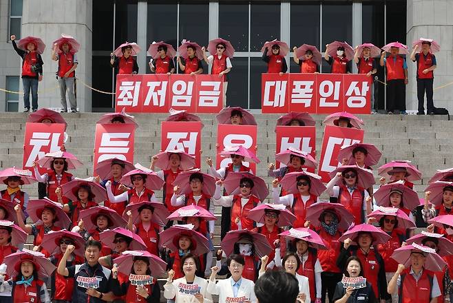 18일 서울 여의도 국회 본청 계단 앞에서 열린 6.18 돌봄노동자 하루멈춤 투쟁 기자회견에서 더불어민주당 이수진 의원, 진보당 전종덕, 정혜경 의원과 서비스연맹 전국돌봄서비스노조 조합원들이 구호를 외치고 있다. 뉴시스