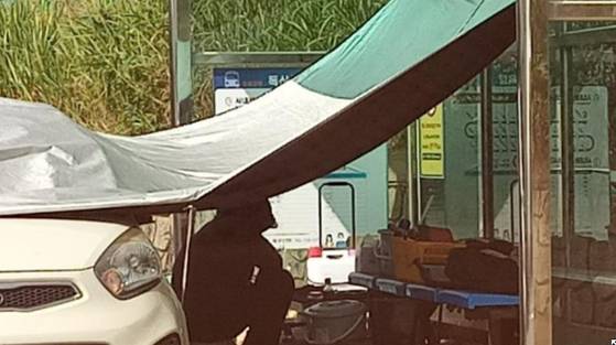버스정류장 구조물을 이용해 천막을 친 모습. 사진 보배드림 캡처